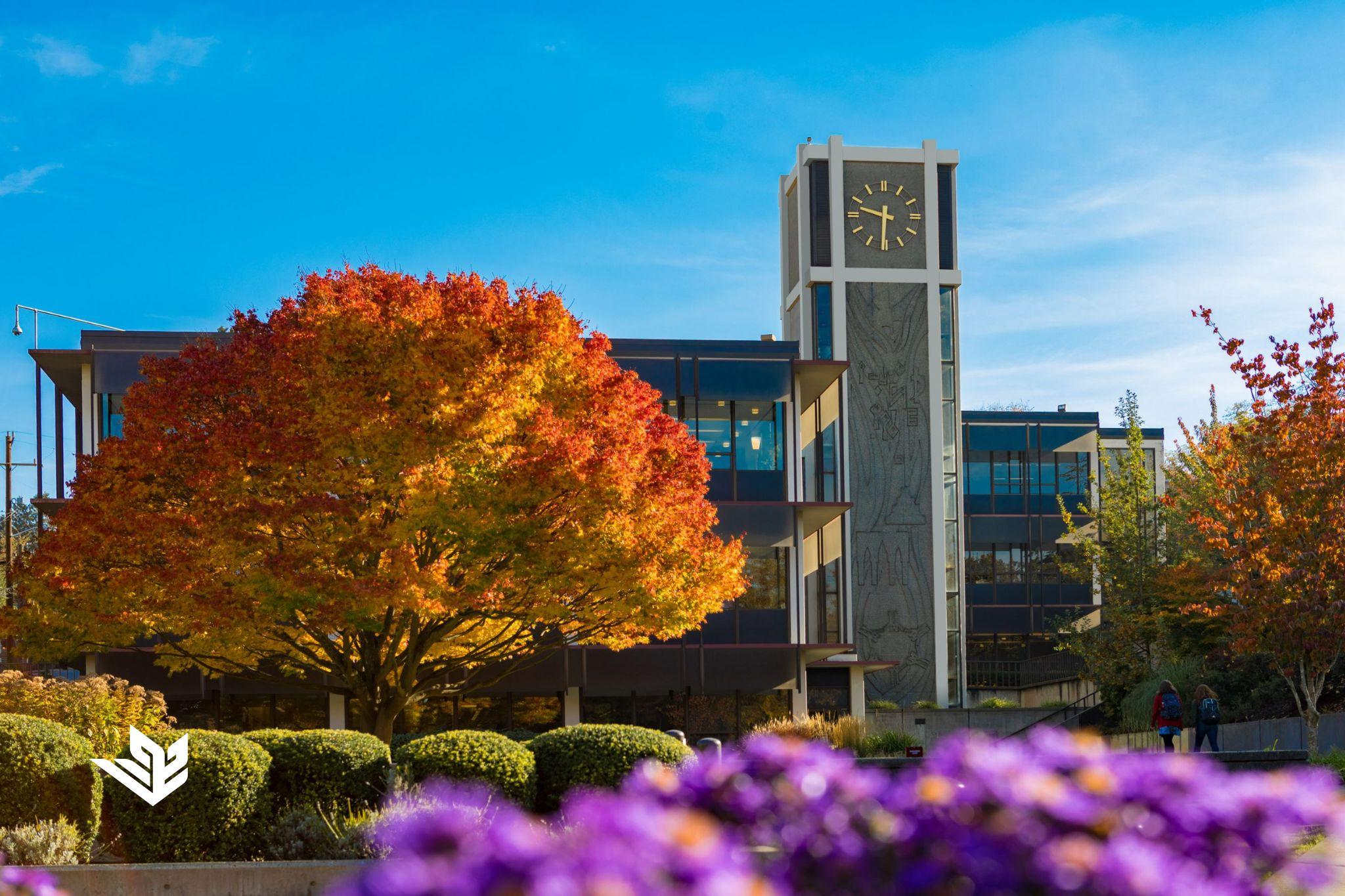 Demaray Hall at Seattle Pacific University during the Autumn Quarter, featuring the fall colors of the surrounding tree and flowers